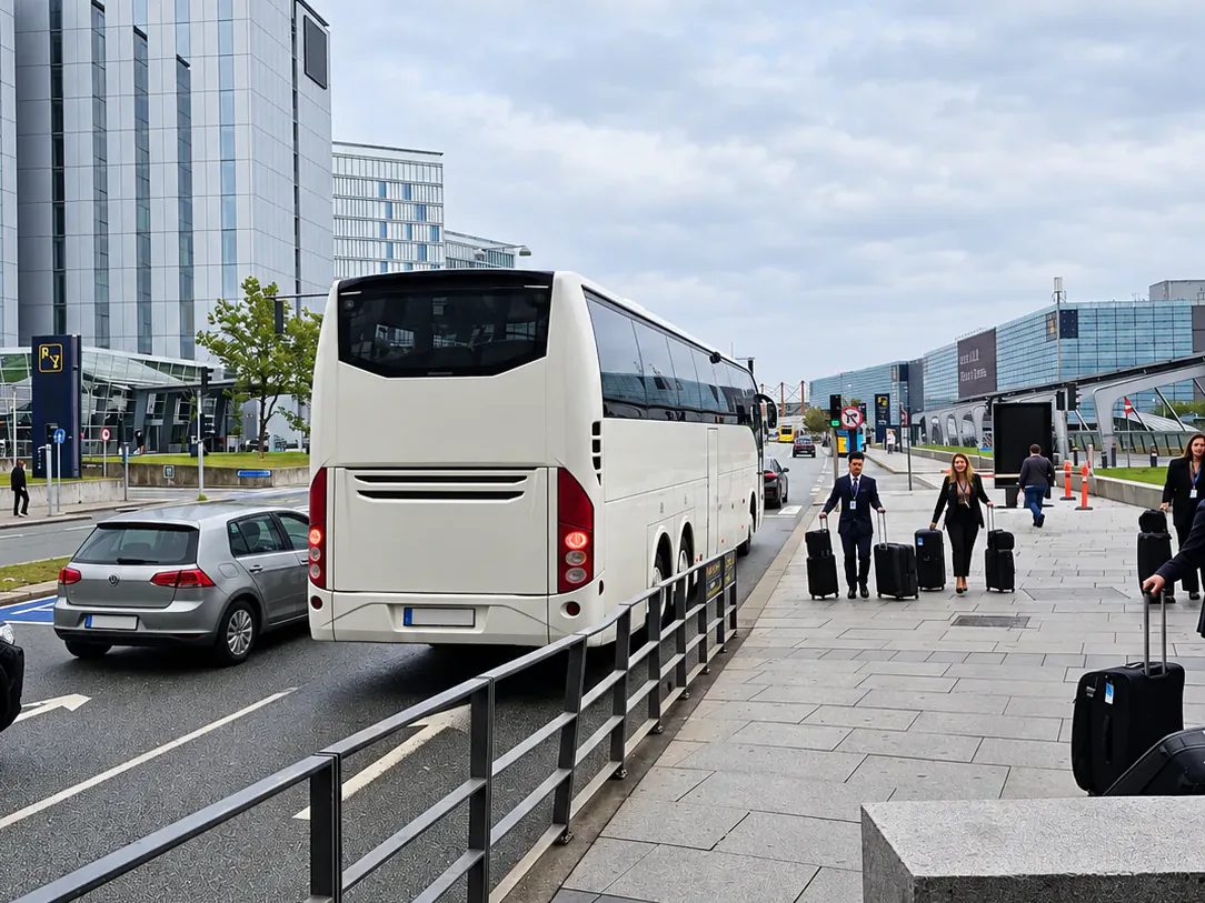BusCom Reisebus am Ankunftsbereich des Flughafens, Reisende mit Koffern gehen darauf zu